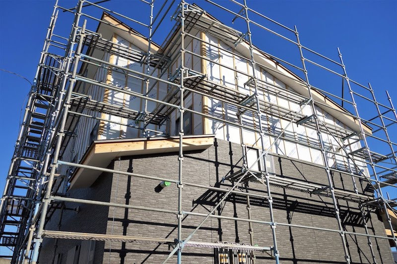 足場が付いたままのレンガの壁の一軒家